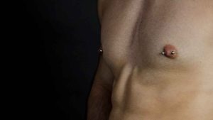 mans chest with double nipple piercings