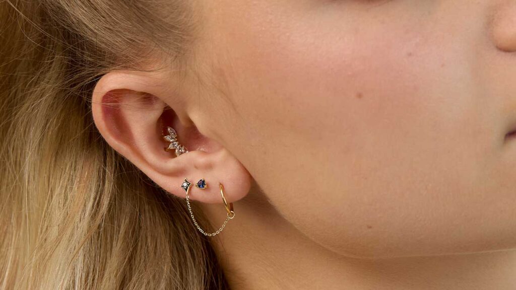 woman with curated ear piercings in 18K gold