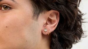 man with double lobe piercings and a lower helix piercing with a ring